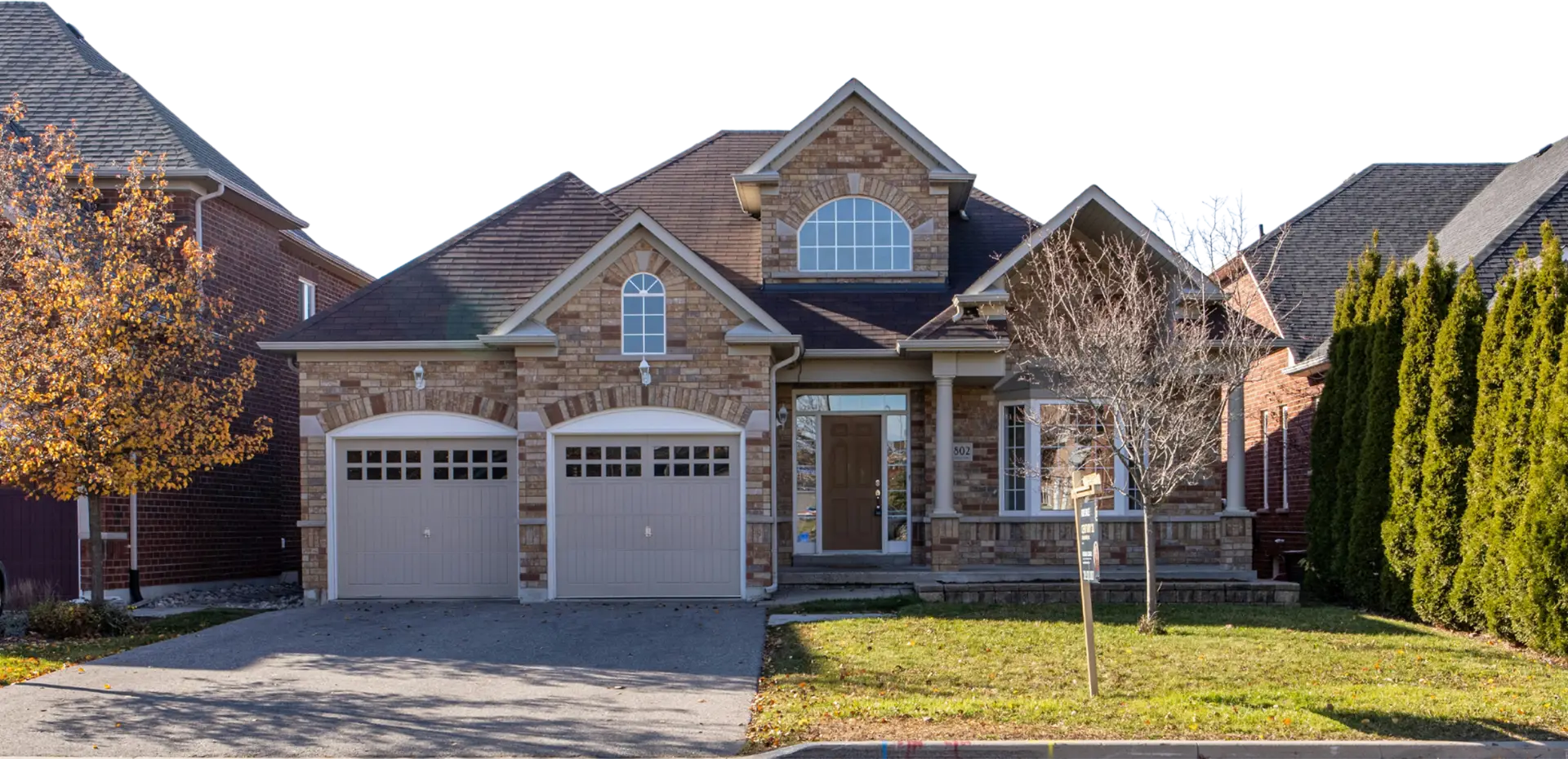 A large brick house with two garage doors.