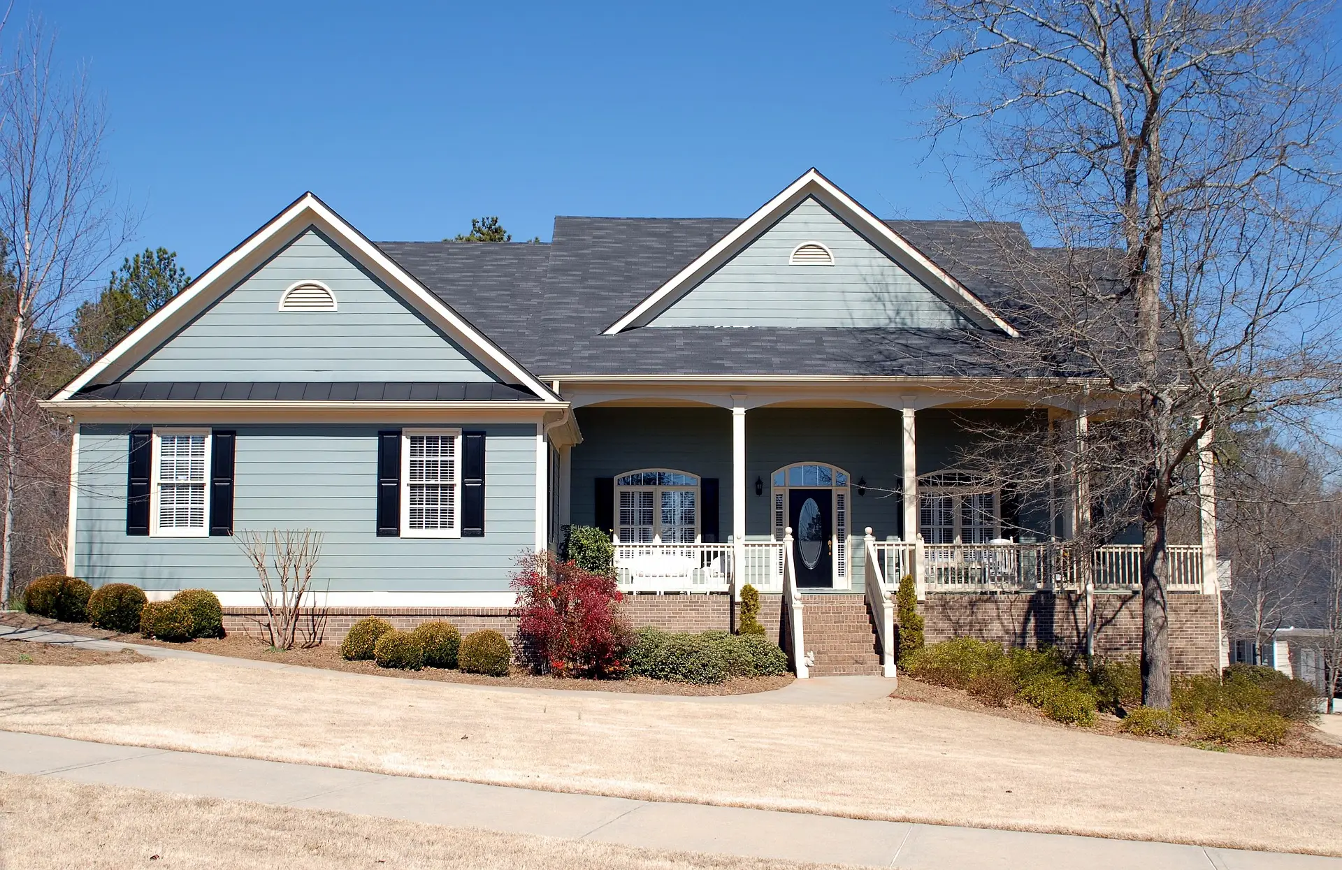 A blue house with a porch and steps leading to the front door.