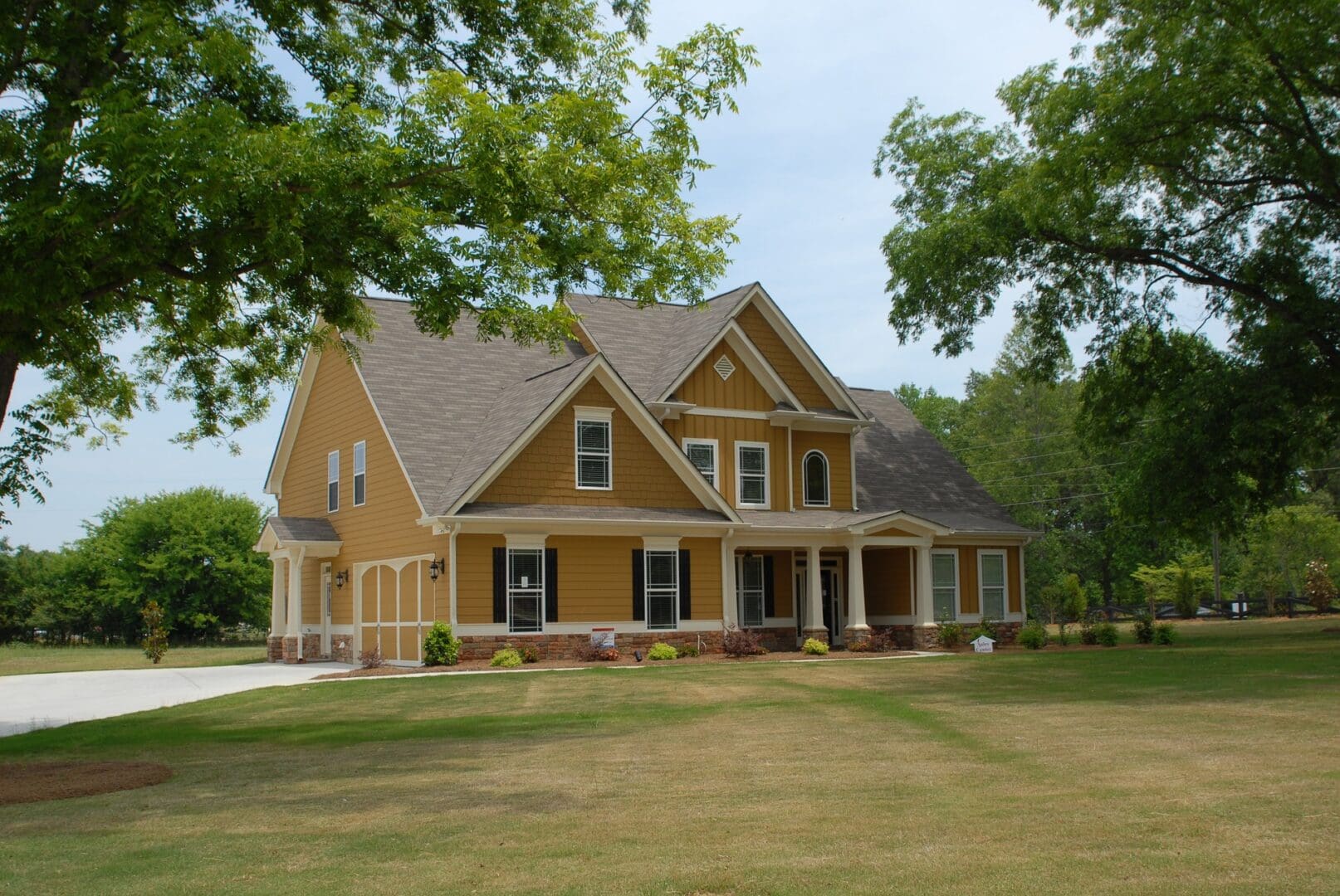 A large yellow house sitting in the middle of a field.