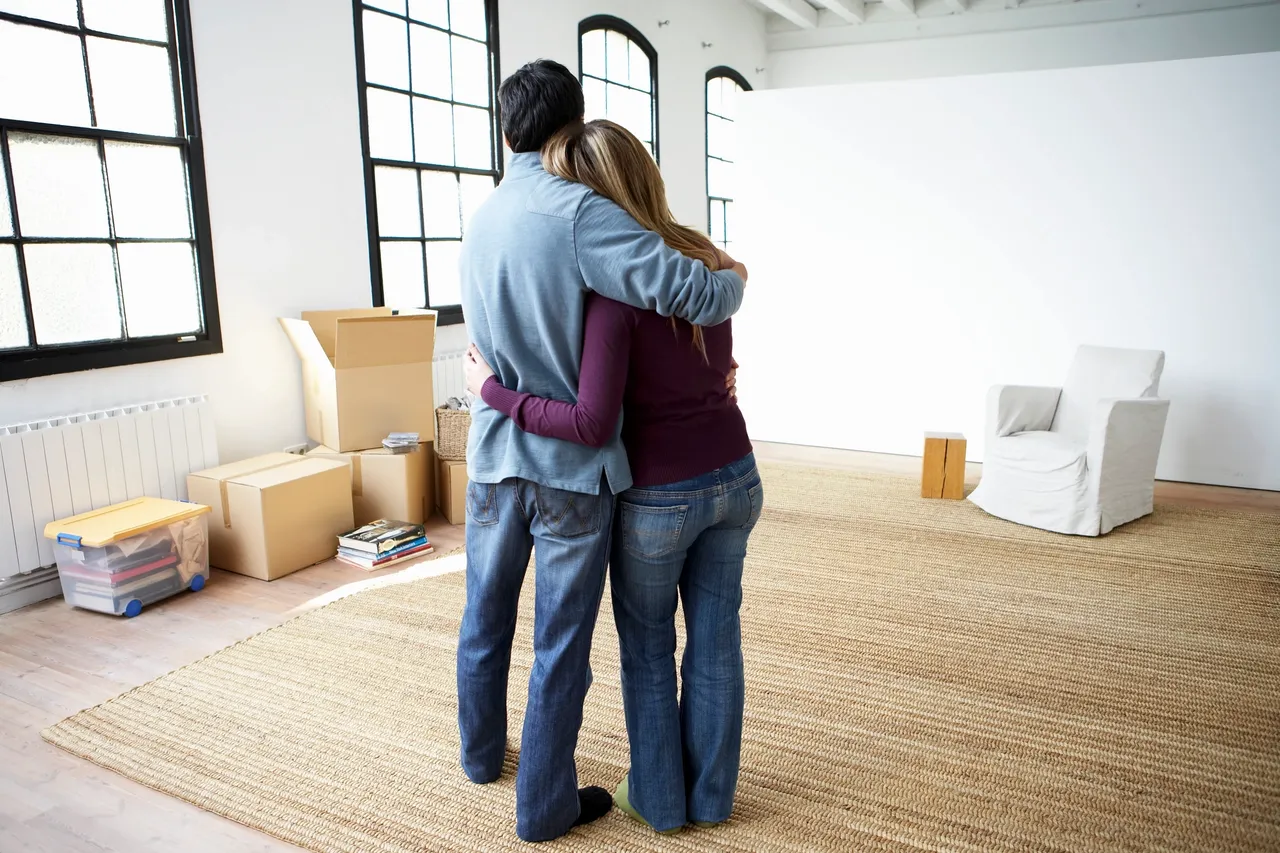 A man and woman hugging in the living room.