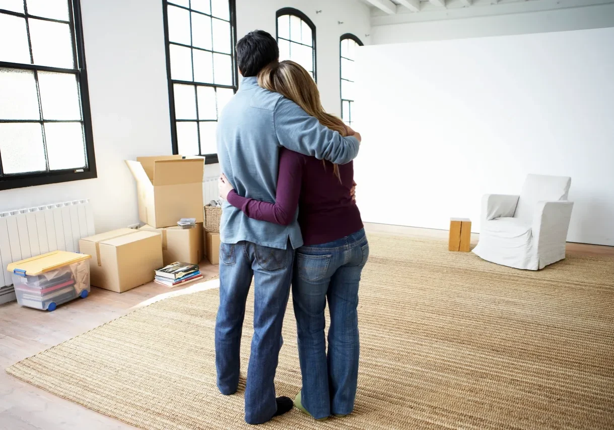 A man and woman hugging in the living room.